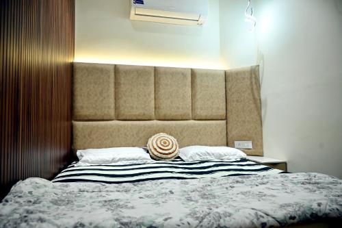 a bedroom with a bed with a large headboard at Ista Inn Homestay in Amritsar