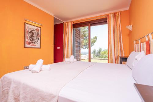 a bedroom with a large white bed and a window at Can Toni Gat in Bunyola