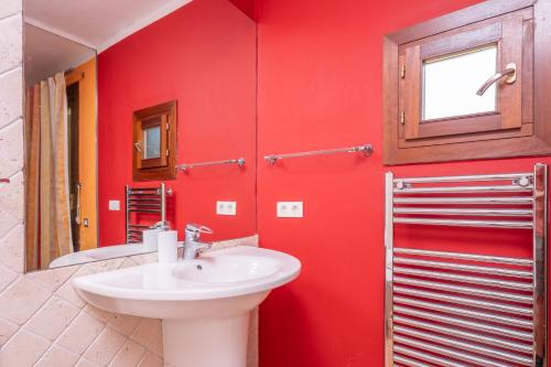 a bathroom with a sink and a red wall at Can Toni Gat in Bunyola