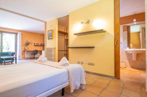 a bedroom with a white bed and a bathroom at Can Toni Gat in Bunyola