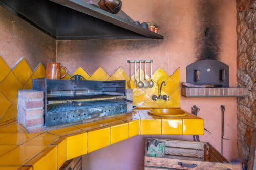 a kitchen with a yellow counter with a sink at Can Toni Gat in Bunyola