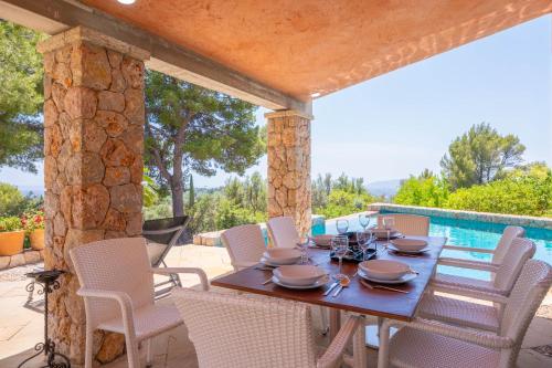 a wooden table and chairs on a patio at Can Toni Gat in Bunyola