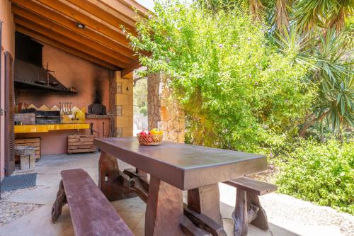 a wooden table and bench on a patio at Can Toni Gat in Bunyola