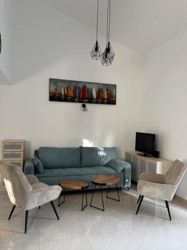 Una sala de estar con un sofá verde y sillas. en Sea Garden House Mandre, en Mandre