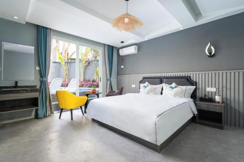 a bedroom with a bed and a table and a yellow chair at Sanya Yalong Bay Zhenghe Jingmei Hostel - Free Public Kitchen in Sanya