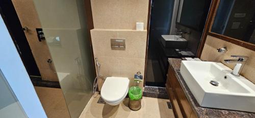 a bathroom with a toilet and a sink at Aamby Valley City in Lonavala