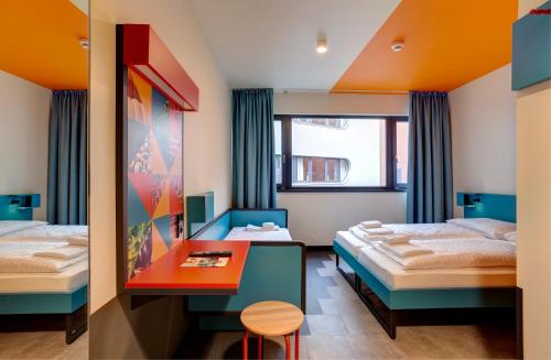 a hotel room with two beds and a table at MEININGER Budapest Great Market Hall in Budapest