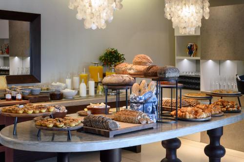 a table with many different types of bread and pastries at Vilalara Grand Hotel Algarve in Armação de Pêra