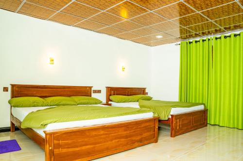 twee bedden in een kamer met groene gordijnen bij Lina Eco Cottage - Ella in Ella