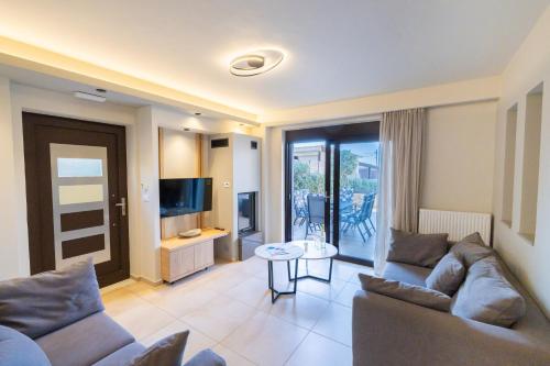 a living room with a couch and a television at Villy Luxury Home by the Sea 1 in Ayiá