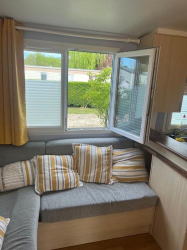 - un canapé dans une petite maison avec 2 fenêtres dans l'établissement Mobil home dans un camping 5 à Deauville, à Saint-Arnoult