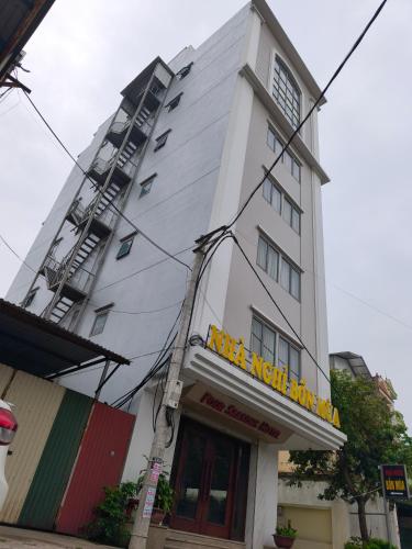 a tall white building with a sign on it at Bốn Mùa Hotel in Dong Anh