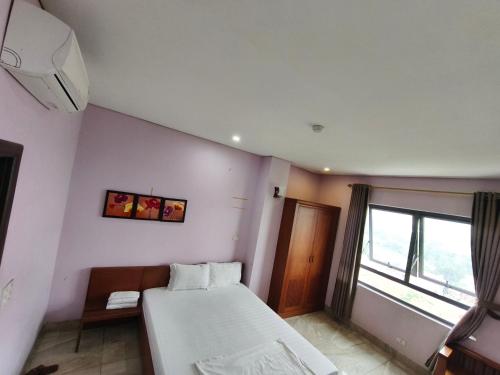 a small room with a bed and a window at Bốn Mùa Hotel in Dong Anh