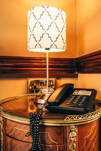 a telephone on a table with a lamp on it at Russell Court Hotel in Dublin