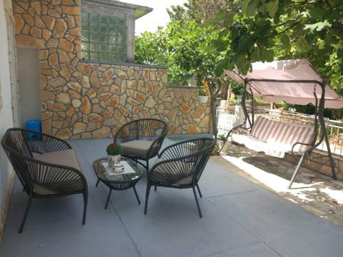 a patio with four chairs and a table and an umbrella at Apartment Josić in Kaštelina