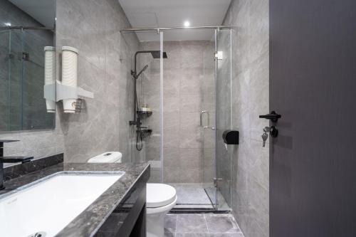 a bathroom with a tub and a toilet and a shower at Sanya Yalong Bay Zhenghe Jingmei Hostel - Free Public Kitchen in Sanya