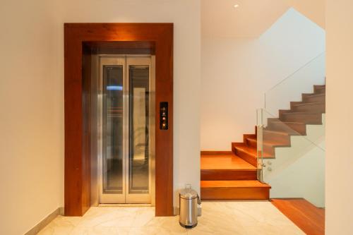 a hallway with a staircase and a glass door at Kensho Marigold 3-BHK Villa Common Pool & Lift Beaches in Majorda