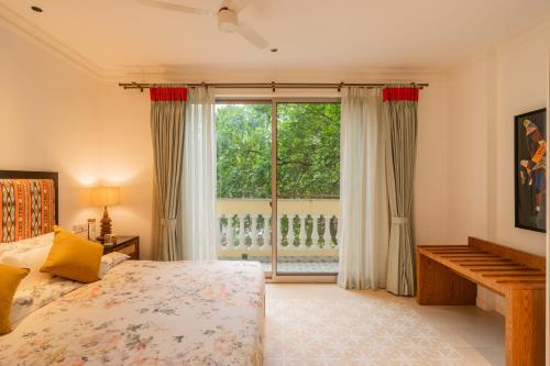 a bedroom with a bed and a large window at Kensho Marigold 3-BHK Villa Common Pool & Lift Beaches in Majorda