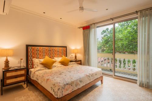 a bedroom with a bed and a large window at Kensho Marigold 3-BHK Villa Common Pool & Lift Beaches in Majorda