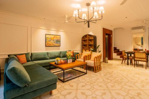 a living room with a green couch and a table at Kensho Marigold 3-BHK Villa Common Pool & Lift Beaches in Majorda