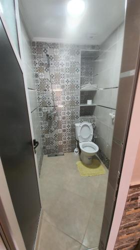 baño con aseo en una habitación con azulejos en wunderschöne Wohnung in Imi Ouaddar, en Agadir nʼ Aït Sa