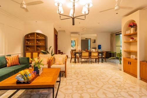 a living room with a couch and a table at Kensho Marigold 3-BHK Villa Common Pool & Lift Beaches in Majorda