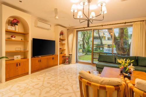 a living room with a couch and a television at Kensho Marigold 3-BHK Villa Common Pool & Lift Beaches in Majorda