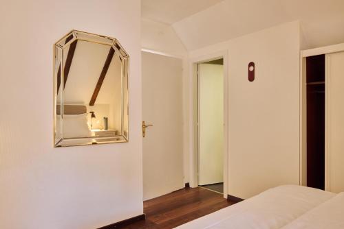 a bedroom with a mirror on the wall at Hotel Schiff am See in Murten