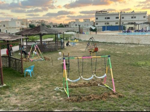 une aire de jeux avec une balançoire dans un champ dans l'établissement الصيف احلى فى الساحل, à El Alamein