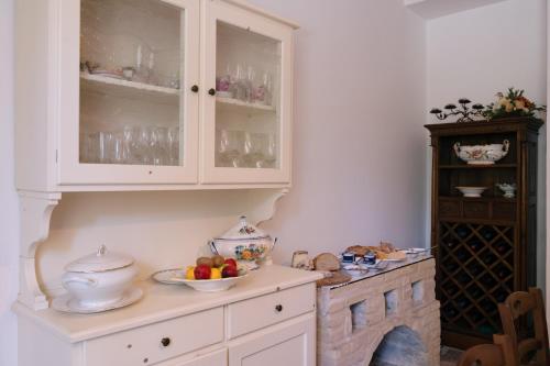 a kitchen with white cabinets and a bowl of fruit at B&B Villa Lory in Fara Filiorum Petri