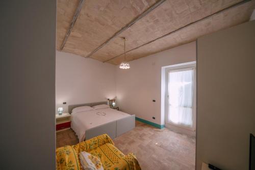 a bedroom with a bed and a couch and a window at B&B Villa Lory in Fara Filiorum Petri