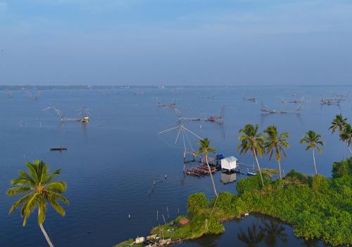 a large body of water with boats and palm trees at JC Den Private Villas Kochi by VOYE HOMES in Cochin