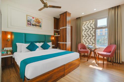 a bedroom with a bed and a table and chairs at Hotel Fiora Inn Chandigarh Zirakpur in Zirakpur