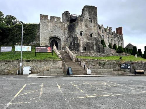 an old castle with stairs in front of a parking lot at Rooftops in Hay-on-Wye