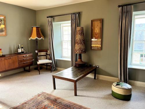 a living room with a table and a chair at Rooftops in Hay-on-Wye