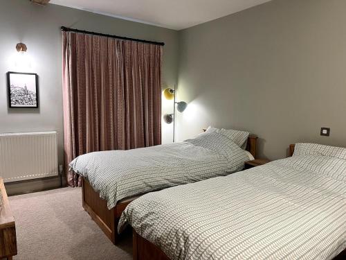 a bedroom with two beds and a window at Rooftops in Hay-on-Wye