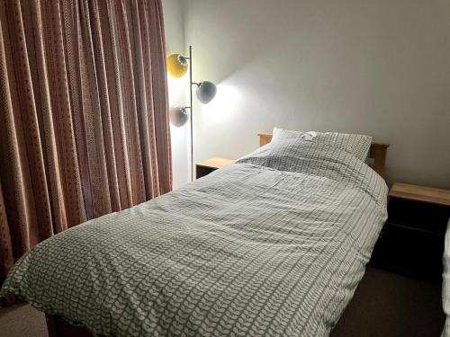 a bed with a white comforter in a bedroom at Rooftops in Hay-on-Wye