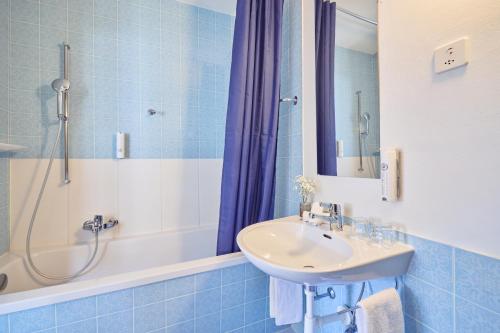 a bathroom with a sink and a shower at Hotel Schiff am See in Murten