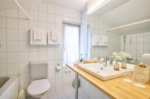 a white bathroom with a sink and a toilet at Hotel Schiff am See in Murten