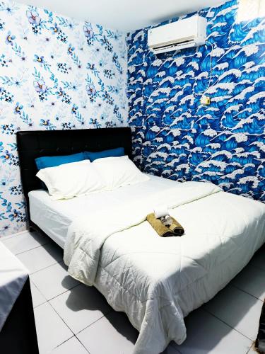a bed in a room with blue and white wallpaper at Chandrady Permata Guest House 2 in Jakarta