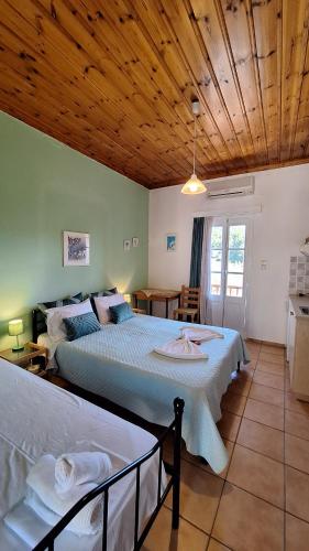 a bedroom with two beds and a wooden ceiling at Armonia Guesthouse in Panormos Skopelos
