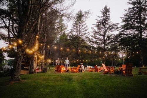 a group of people standing in a yard with lights at Camp DeForest in Lincolnville
