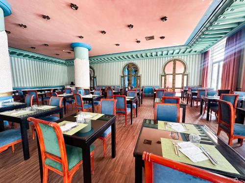 a dining room with tables and chairs in a restaurant at Grand Mogador Agdal & Spa in Marrakech