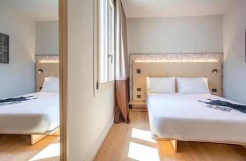 a bedroom with two beds and a mirror at Hotel Casa W in Venice