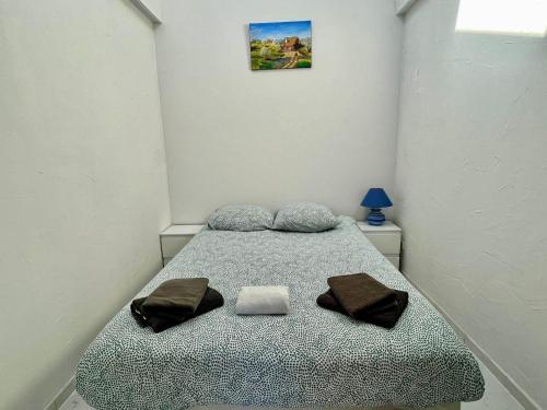 une chambre avec un lit avec deux serviettes dessus dans l'établissement Maisonnette, à 50m de la mer avec terrasse, à Luc-sur-Mer
