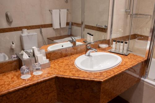 a bathroom counter with a sink and a mirror at Grand Millennium Dubai in Dubai
