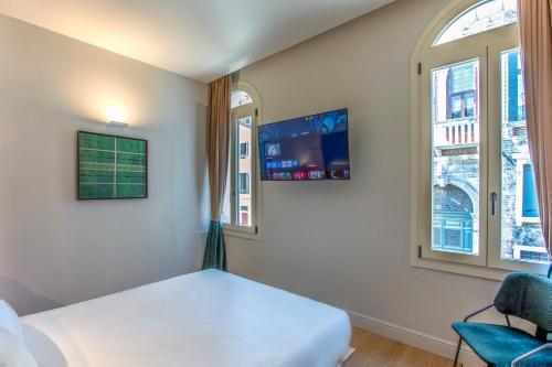 a bedroom with a white bed and two windows at Hotel Casa W in Venice