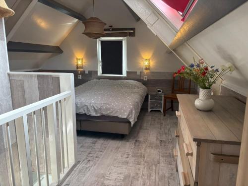 een slaapkamer met een bed en een vaas met bloemen bij Casa Sea 2 personen en Casa Beach 4 personen in Westkapelle