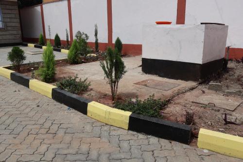 a yellow and black curb in front of a building at Axis Guest House in Syokimau