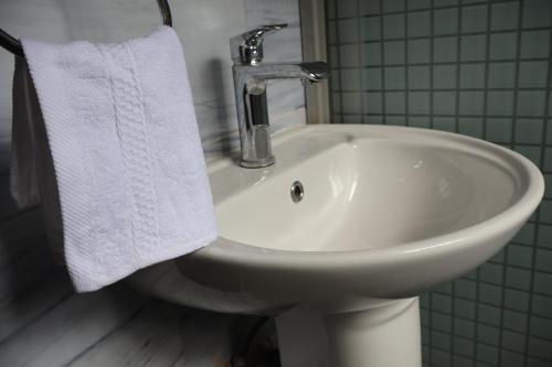 a white sink in a bathroom with a towel at Axis Guest House in Syokimau